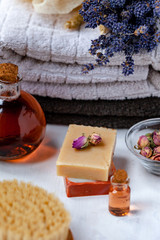 Obraz na płótnie Canvas Concept of natural organic spa products, decor for bath. Home body treatment. Handmade herbal soap, organic oil in glass bottle, lavender, brush, towels. Atmosphere of relax, serenity and pleasure.