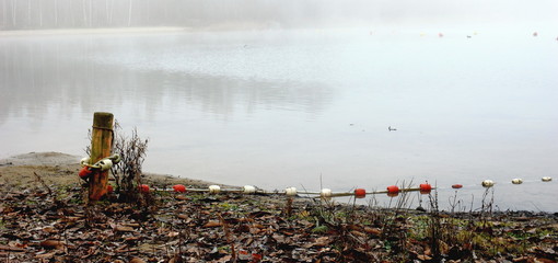 Foggy, wintery images of a lake: the Plas in Rotselaar in Flanders, Belgium. De Plas is an artificial lake created by sand extraction.  Swimming and windsurfing in the summer.