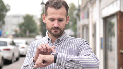 Obraz premium Beard Casual Man Using Smartwatch Outdoor