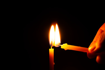 One candle is lit from another candle which has a fire.