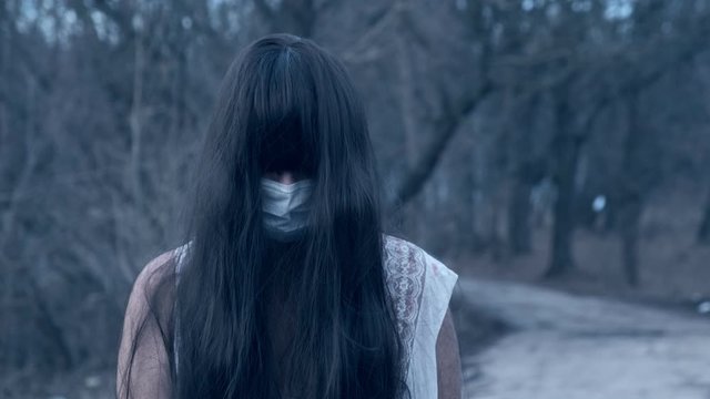 Portrait of ghost of dead girl in bactericidal mask on her face protected from corona virus.