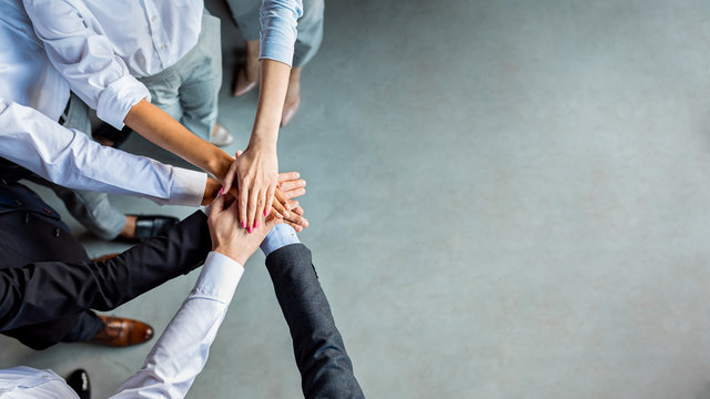 Unrecognizable Business People Holding Hands Standing In Modern Office, Above-View