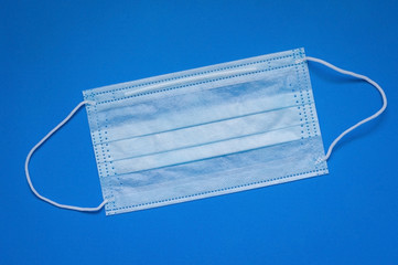 disposable medical mask on a blue background.