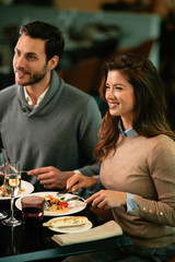 Fototapeta na wymiar Happy loving couple enjoying in restaurant. Young couple enjoying in food.