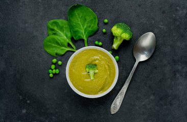 Broccoli, spinach, green peas soup on a stone background