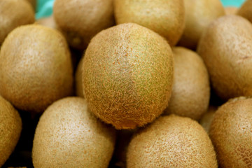 Closeup Fresh Kiwi Fruit on blurry Kiwi Fruits Pile