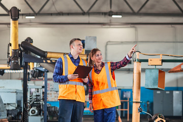 Male and Female Industrial Engineers Have Discussion and Using Tablet. They Work in a Industry Factory.