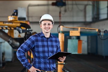 male worker with Hard Hats smile and use tablet at industrial factory
