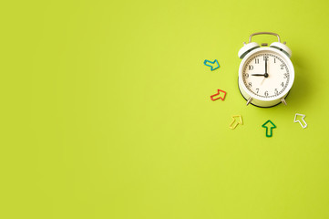 White vintage alarm clock on bright green background. Top view, copy space.