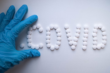 врач лекарства, доктор в синей перчатке раскладывает белые таблетки