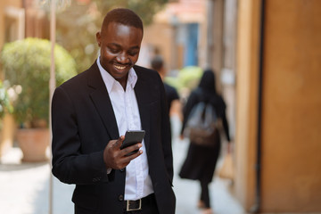 African business man using his smartphone in the city