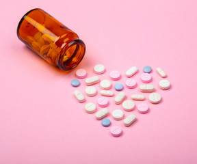 Flacon de médicaments avec forme de coeur, arrière-plan rose