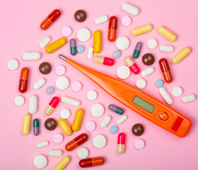 Médicaments et thermomètre avec arrière-plan rose