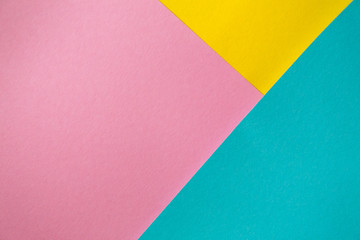 Colored paper lying on top of each other. Pink, blue, yellow thick paper. Colored bright paper background.