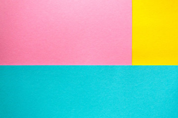 Colored paper lying on top of each other. Pink, blue, yellow thick paper. Colored bright paper background.