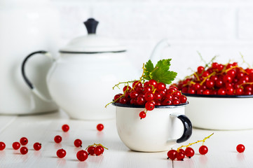 Red currant berries in a cup and bowl on the kitchen table