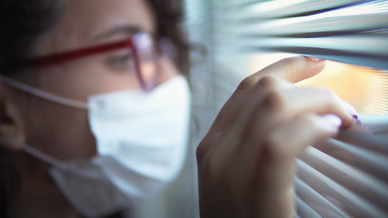 Corona Virus Quarantine Isolation. Sick woman of corona virus looking through the window and...