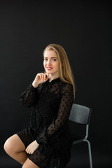 Fototapeta premium beautiful young woman in a black dress on a black background
