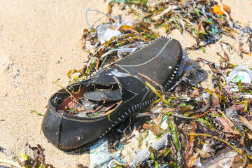 Closeup plastic trash on the sandy beach of a tropical sea