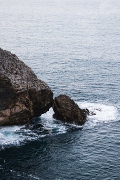 Rocas que parecen besarse junto al mar agitado