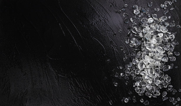 Pile of crushed ice on black stone background