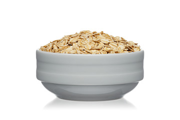 Oatmeal in a white ceramic bowl isolated on a white background.