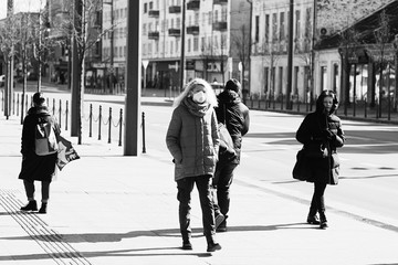 Obraz premium COVID-19 Pandemic Coronavirus Young girl in city street wearing face mask protective for spreading of Coronavirus Disease 2019. Close up of young woman with surgical mask on face against