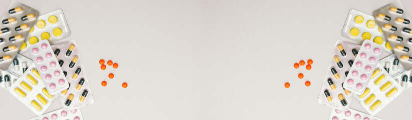 Heap of medical pills in yellow, pink and green colors. Pills in plastic package.