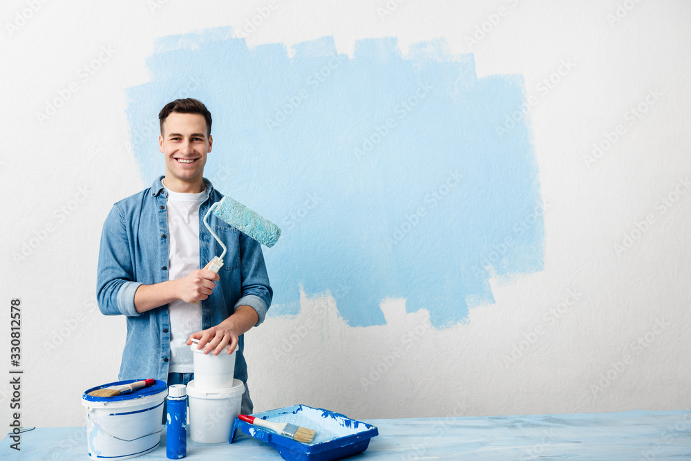 Wall mural smiling young man with tools and paint