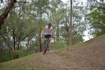 Obraz premium Joven latino montando bicicleta en un bosque y en un parque