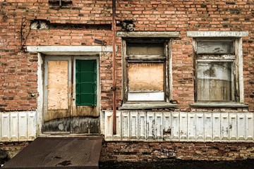 old weathered brick wall building with wooden door and windows