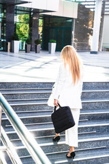 Young business woman in white suit outside