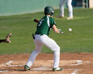 Young boy swinging the bat for a hit in a baseball game