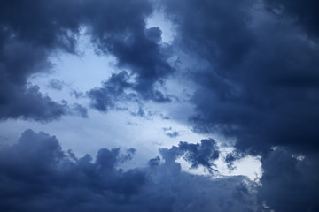 Blue sky with dark storm clouds at sunset