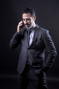 Uomo in abito parla al telefono, Isolato su sfondo nero
