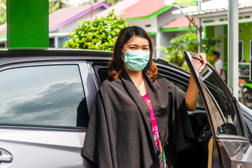 Young Asian woman get out of the car using  face mask to prevent Corona virus or Covid-19 virus outbreak