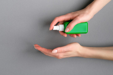 Woman applying hand sanitizer in spray bottle. Coronavirus Disease (Covid-19) prevention concept.