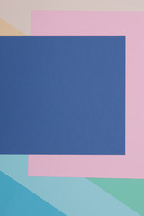Blue, green, yellow and pink background, colored paper geometrically divides into zones, frame, copy, space.