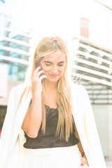 Young business woman in white suit outside