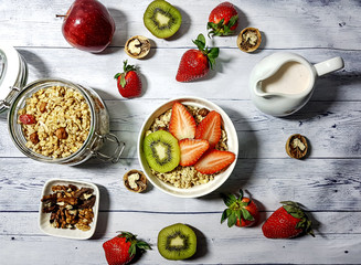 Healthy Food. Delicious granola breakfast with yogurt, kiwi, strawberries and nuts.
