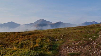 Peak of the mountains surrounded by morning fog in autumn