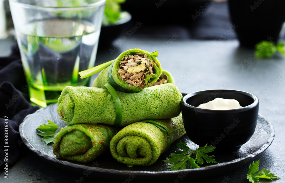 Wall mural green pancakes with spinach, filling with liver and eggs. selective focus