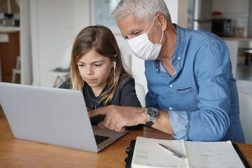 Fototapeta premium Father and child at home working on laptop, telework and home-schooling