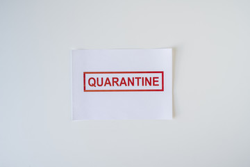 The word quarantine on a sheet of paper lying on an office desk. Worldwide pandemic concept, production and work shutdown