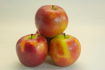 Three red apples close-up on a light background. Healthy food concept.