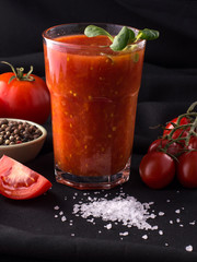 tomato juice in a glass on a black background.