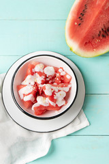 Watermelon fruit cutted with yogurt in bowl on turquoise background