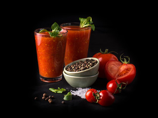 tomato juice in a glass on a black background.