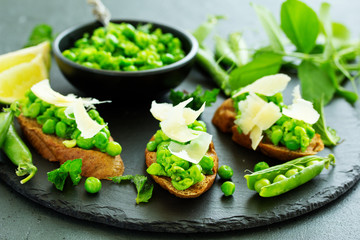 Crostini with pea puree, mint and parmesan. Snack.