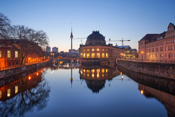Fototapeta premium Berlin, Germany, Museum Island on Spree river and TV tower in the background at sunrise, Bode-Museum, cityscape early in the morning, reflections in the water, beautiful blue sky, dusk